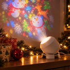 Projection light on a shelf, tilted towards the wall and casting a snowman pattern, with pine branches and presents beside it